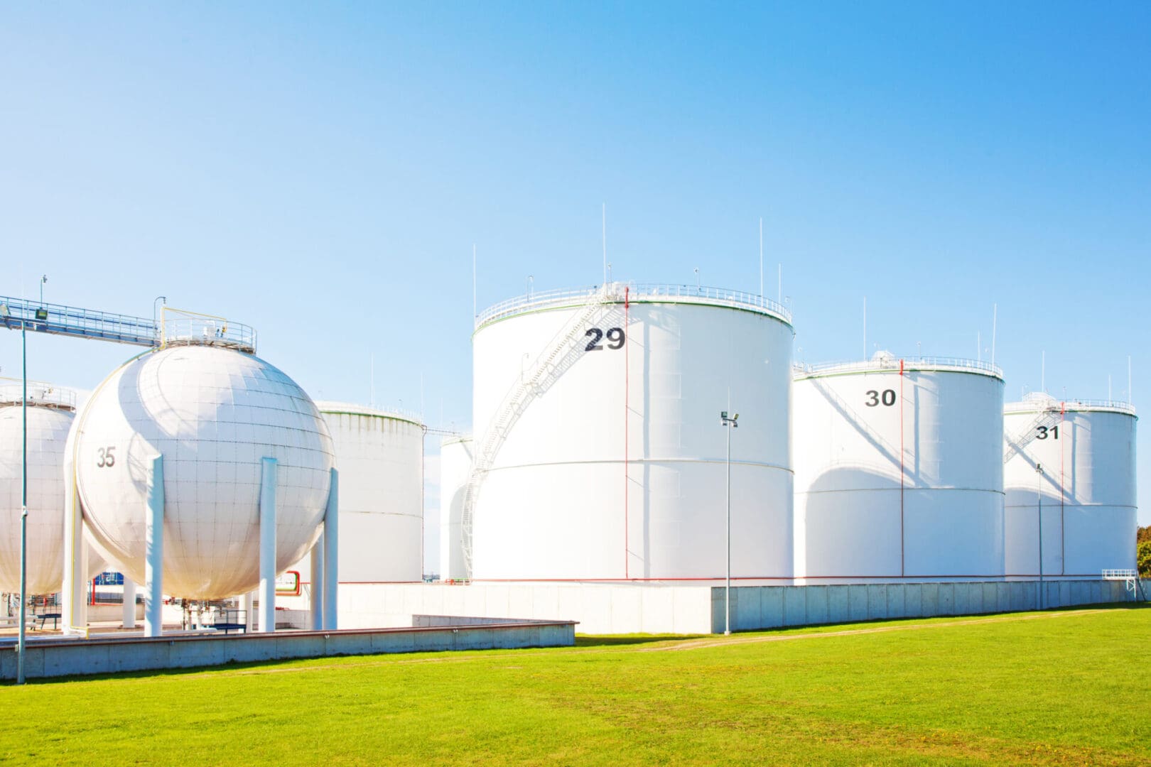 Oil refinery plant and petrol storage tanks over blue sky