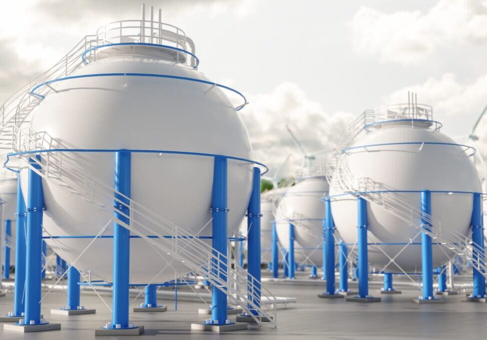 Close-up Of Storage Tanks With Wind Turbines Background